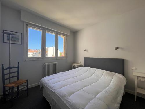 ein Schlafzimmer mit einem großen weißen Bett und einem Fenster in der Unterkunft Appartement Saint-Jean-de-Luz, 3 pièces, 5 personnes - FR-1-239-962 in Saint-Jean-de-Luz