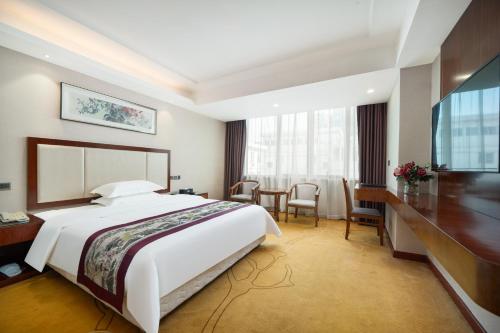 Habitación de hotel con cama grande y escritorio. en Honglilai Hotel, en Bao'an