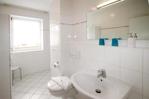 キュールングスボルンにあるStrandschloesschen-I-WE-16-679の白いバスルーム(洗面台、トイレ付)