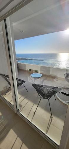 einen Balkon mit einem Tisch und Stühlen sowie Meerblick in der Unterkunft ayllu in Arica