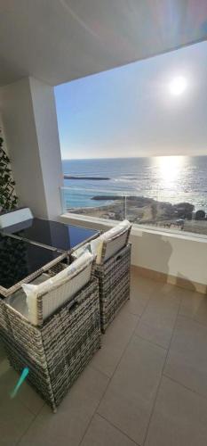 a balcony with two wicker baskets and a view of the ocean at ayllu in Arica