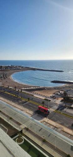 a red train on a road next to the ocean at ayllu in Arica