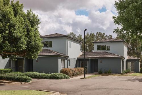 a large white house with a street at Rydges Resort Hunter Valley in Lovedale