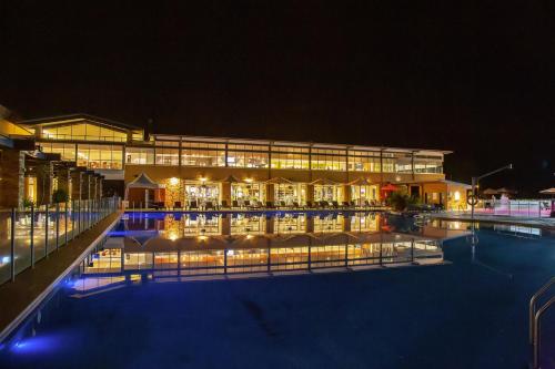 a large building with a swimming pool at night at Rydges Resort Hunter Valley in Lovedale