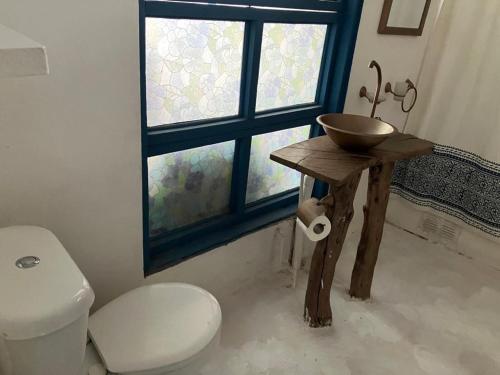 uma casa de banho com um lavatório, um WC e uma janela. em Santorini house y Santorini house 2 em San Pedro de Atacama