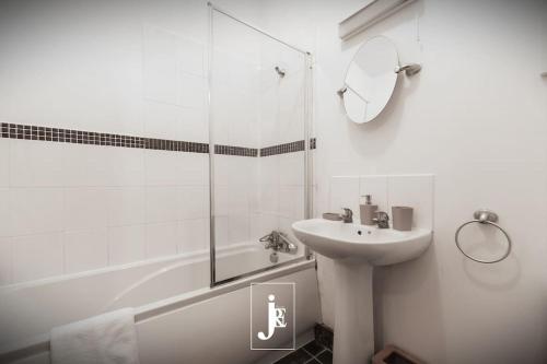 a white bathroom with a sink and a shower at The Port Solent City Apartment - Southampton, Portsmouth in Southampton