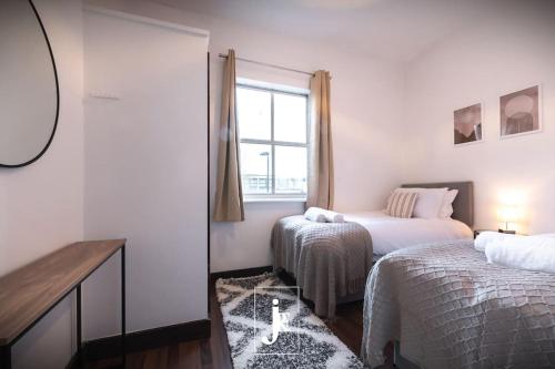 a white room with two beds and a window at The Port Solent City Apartment - Southampton, Portsmouth in Southampton