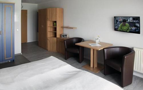 Zimmer mit einem Tisch, 2 Stühlen und einem TV in der Unterkunft Yachthafenresidenz - Wohnung 9304 / 888 in Kühlungsborn