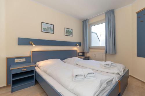 キュールングスボルンにあるYachthafenresidenz-Wohnung-6303-773のベッドルーム1室(ベッド1台、タオル2枚付)