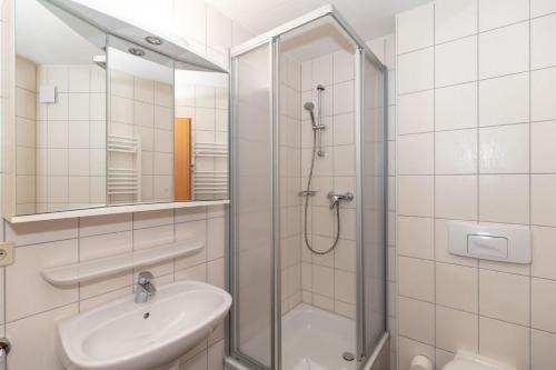 a white bathroom with a shower and a sink at Yachthafenresidenz-Wohnung-6303-773 in Kühlungsborn