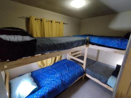a room with three bunk beds with blue sheets at Parcela fuentes in Cartagena