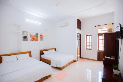2 camas en una habitación con paredes blancas en Lavie House 3 - Số 14 Nguyễn Hiền en Vung Tau