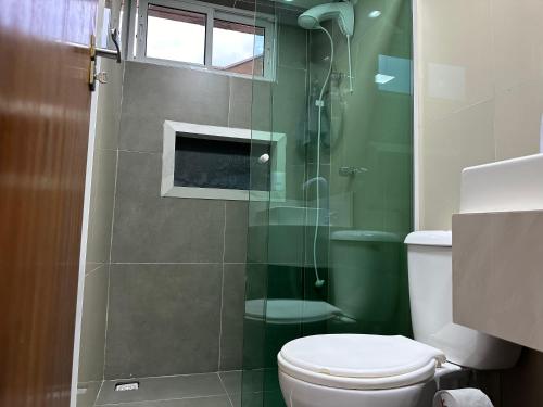 a bathroom with a toilet and a glass shower at Moradas Desterro, próximo ao aeroporto 03 in Florianópolis