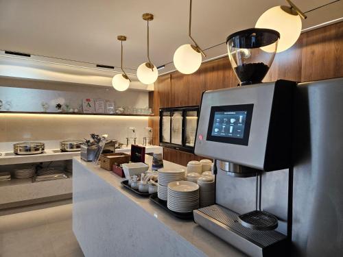 uma cozinha com um balcão com pratos e uma máquina de café em Best Western Newmarket Inn & Suites em Auckland