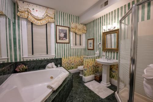 a bathroom with a tub and a toilet and a sink at Antrim 1844 in Taneytown