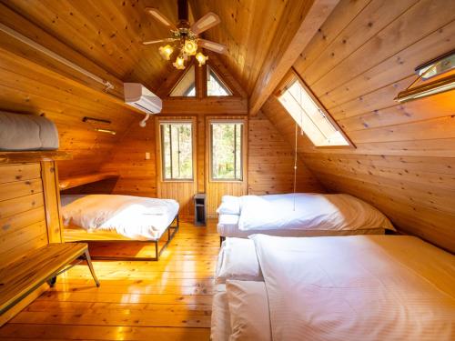 Habitación con 2 camas en una cabaña de madera en スイートヴィラ NASU四季リゾート en Nasu