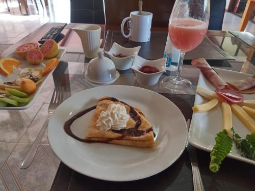 a table with a plate of food and a glass of wine at Atavai Hotel Rapa Nui in Hanga Roa