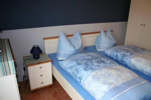 キュールングスボルンにあるBuesumer-Ring-Ostsee-traum-476のベッドルーム1室(青い枕付きのベッド2台付)