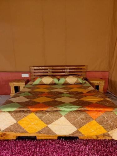 a bedroom with a colorful quilt on a bed at Empyrean Tarry in Igatpuri
