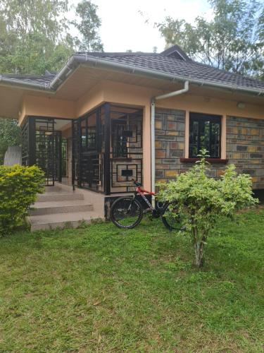 ein kleines Haus mit einem Fahrrad im Hof in der Unterkunft Christa's haven in Siaya