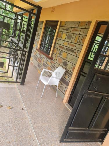 a white chair sitting in front of a building at Christa's haven in Siaya