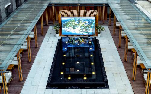 a room with tables and chairs and a large screen at Yancheng Shuicheng Hotel in Yancheng