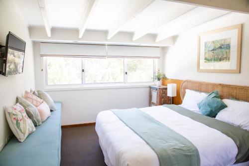 Un dormitorio con una cama grande y una ventana en Chalet La Piste (Private Chalet at The Sebel Pinnacle Valley) en Merrijig