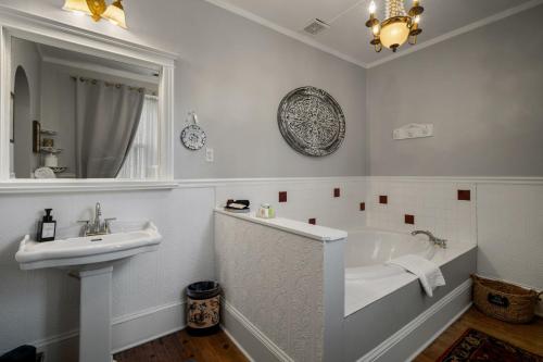 a white bathroom with a tub and a sink at The Inn on Front Street in Statesville