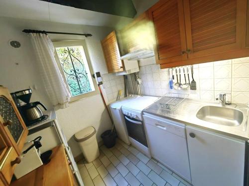 une petite cuisine avec un évier et une fenêtre dans l'établissement Villa Mitoyenne T4 avec Piscine, Terrasse, Parking et Proche Plage - Animaux Bienvenus - FR-1-607-179, au Cap d'Agde