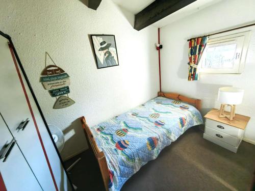 une petite chambre avec un lit et une fenêtre dans l'établissement Villa Mitoyenne T4 avec Piscine, Terrasse, Parking et Proche Plage - Animaux Bienvenus - FR-1-607-179, au Cap d'Agde