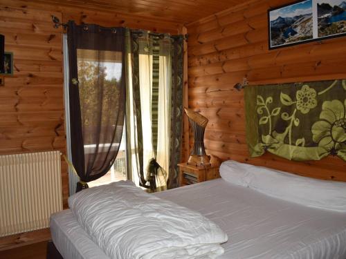 une chambre avec un lit dans une cabane en rondins dans l'établissement Appartement cosy 2 pièces cabines, 6 pers, proche pistes, terrasse - FR-1-592-65, à Bolquère-Pyrénées 2000