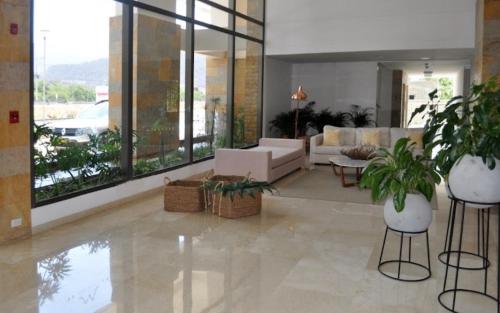 a living room with a couch and some plants at Samaria club de playa Santa marta in Gaira