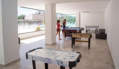 two people playing ping pong in a room with tables at Samaria club de playa Santa marta in Gaira