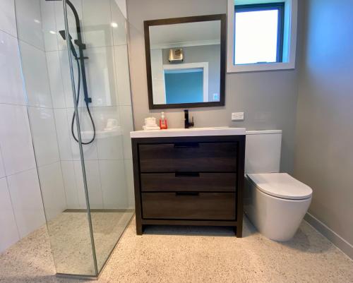 a bathroom with a sink and a toilet and a mirror at Central, Cosy, Convenient in Twizel