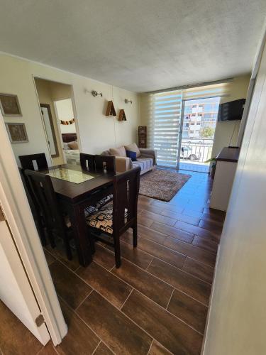a living room with a table and chairs and a couch at Departamento grande cercano a la playa La Serena in La Serena