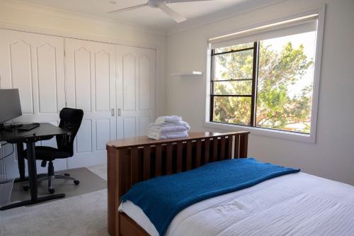 um quarto com uma cama, uma secretária e uma janela em Resort Style home close to the Beach with Pool, Sauna and Pizza Oven em Sidney