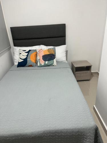 a bed with two pillows on it in a room at Samaria club de playa Santa marta in Gaira