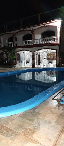 a swimming pool at night with white chairs around it at Casarão Farol da Marise Sol in Belém