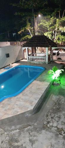 una piscina en un patio por la noche en Casarão Farol da Marise Sol, en Belém