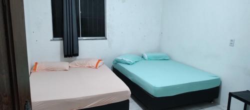 dos camas sentadas una al lado de la otra en una habitación en Casarão Farol da Marise Sol, en Belém