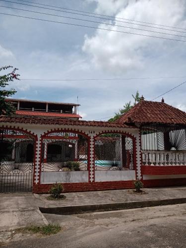 un edificio rojo y blanco con cenador en Casarão Farol da Marise Sol, en Belém