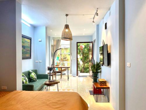 a bedroom with a bed and a living room at Azalea Apartment in Hanoi