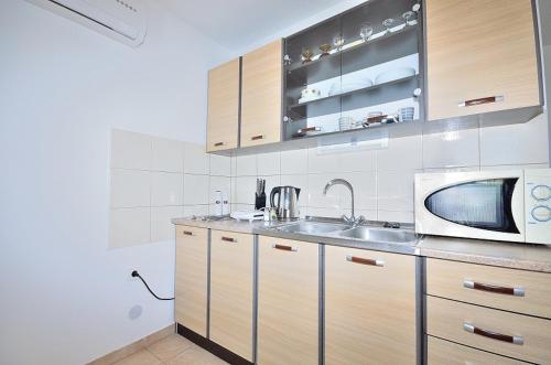 La cuisine est équipée d'un évier et d'un four micro-ondes. dans l'établissement Apartments Lavanda Vodice, à Vodice