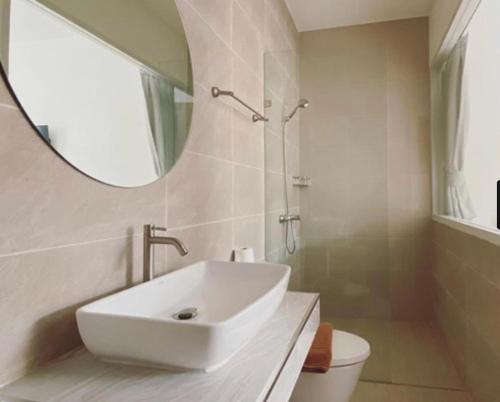 een witte badkamer met een wastafel en een spiegel bij Thandara kohlarn in Ko Larn