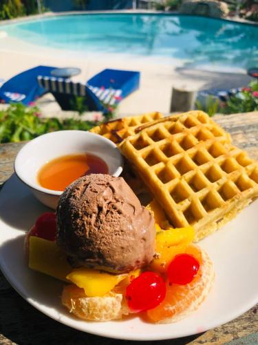 a plate with a chocolate ice cream and waffles and syrup at Wae Molas Hotel in Labuan Bajo