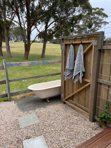a bath tub next to a woodenshed with a bath tub at Marlo Hideaway in Marlo