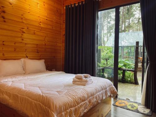 a bedroom with a bed with a teddy bear on it at T'MĂNG ĐEENG HOMESTAY in Kon Von Kla