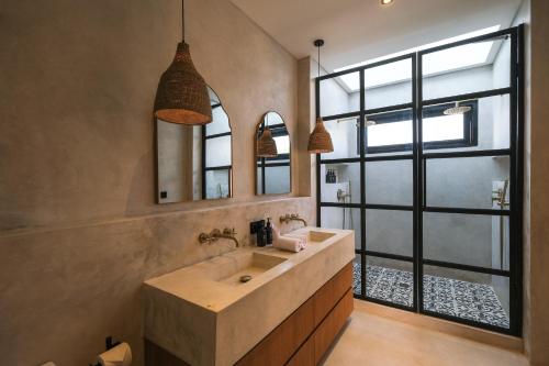a bathroom with a large sink and a large window at Villa Sama Canggu in Canggu
