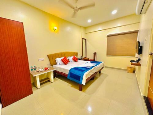 ein Schlafzimmer mit einem Bett und einem TV in der Unterkunft Sunlight Residency in Chennai