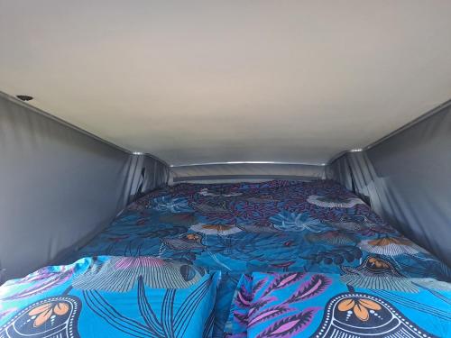 - un petit lit dans une petite chambre avec un couvre-lit dans l'établissement Van Vadrouil, à Saint-Pierre
